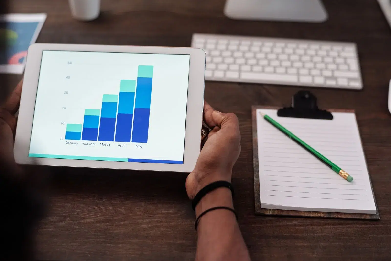 Tablet showing a rising growth chart — backlinks compound into long-term business returns