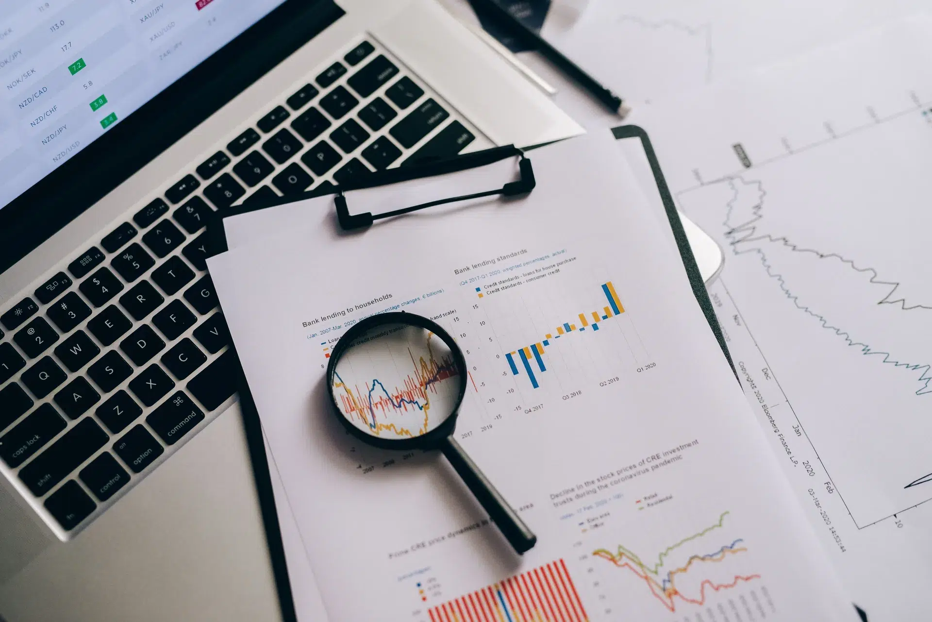 Magnifying glass over charts and a laptop — backlinks help Google discover new pages