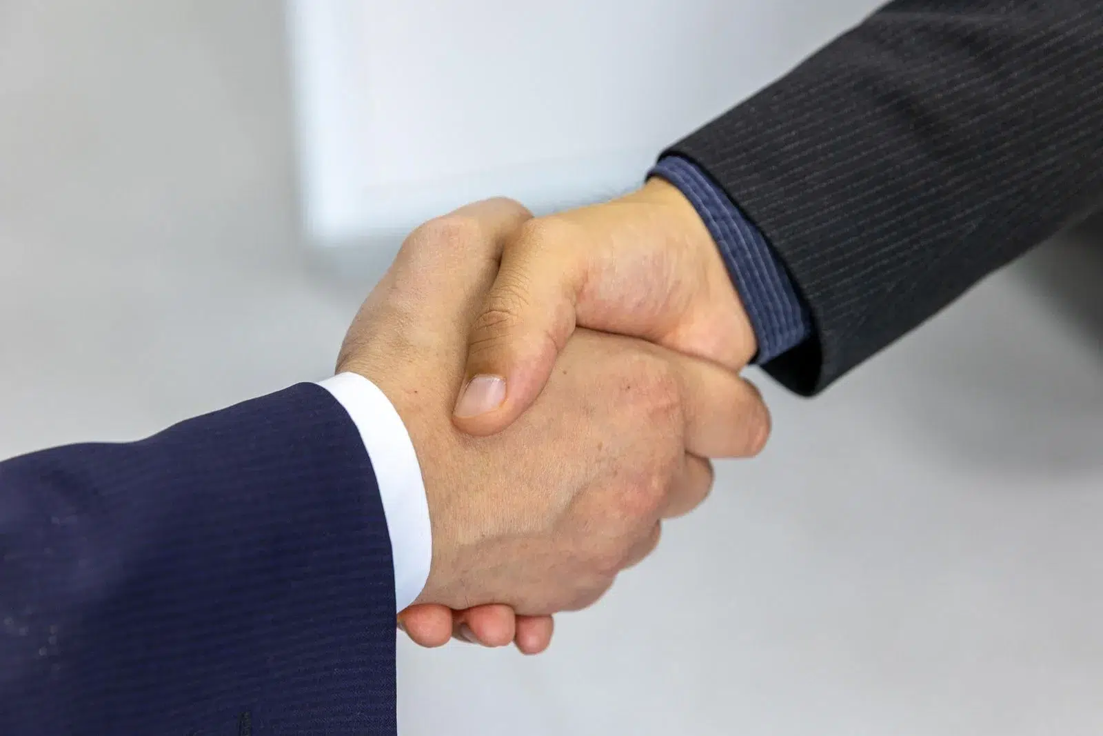 Two business professionals shaking hands — link acquisition is about earning endorsements through relationships